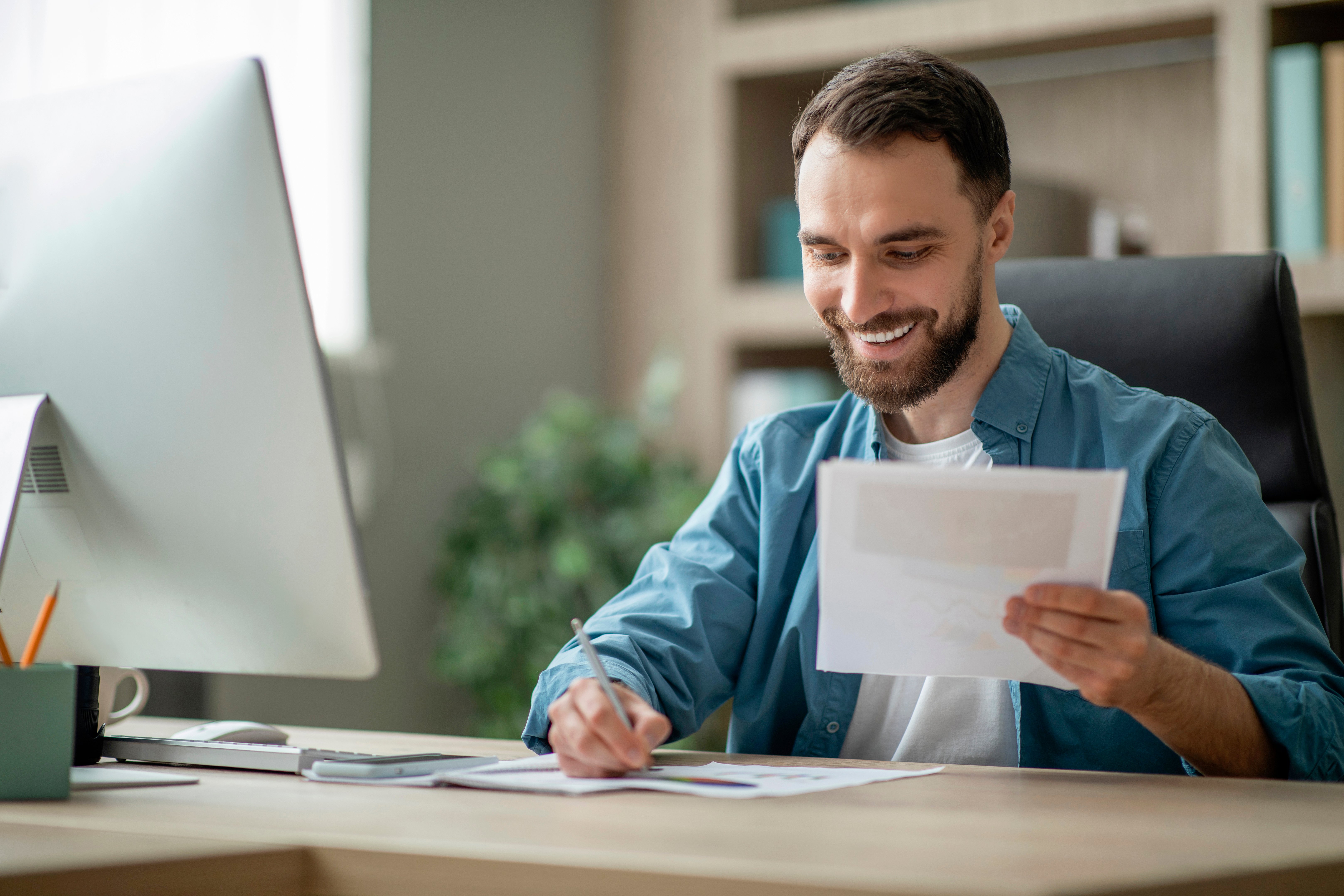 smiling-young-businessman-working-with-papers-at-d-2023-11-27-04-51-43-utc